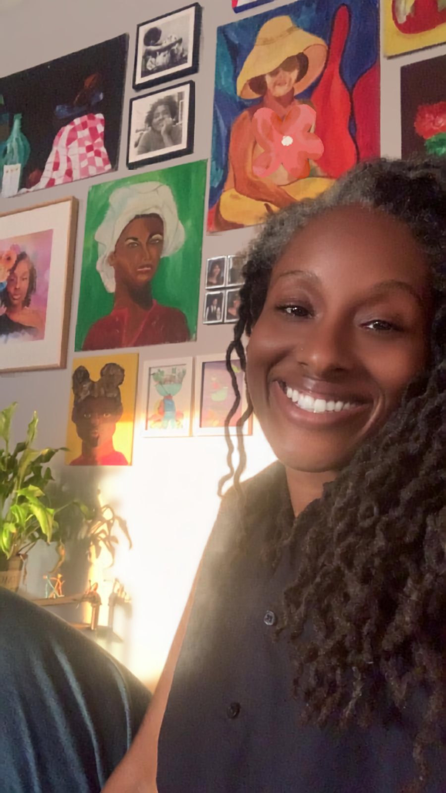 Izetta Henderson, founder of Beauty Boone, smiling in front of a wall of art